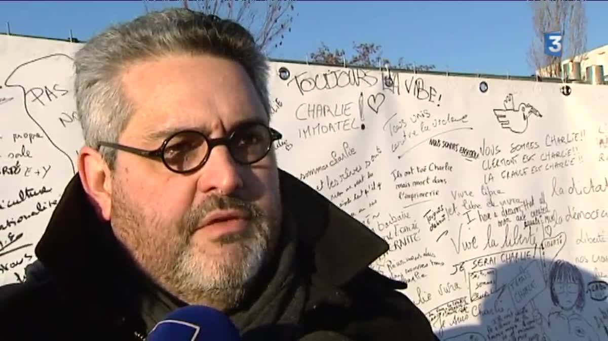 Photo prise le 7 janvier 2015 devant l'ambassade de France à Berlin (Allemagne), présentant les caricaturistes Cabu, Charb et Wolinski.