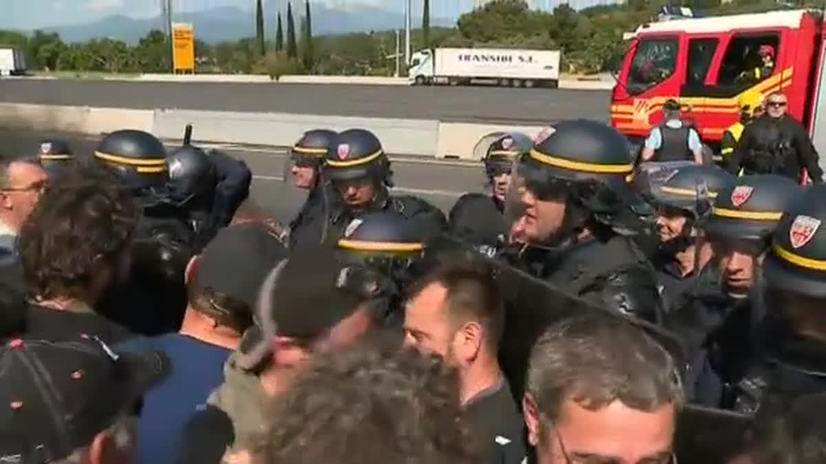 Rassemblés en groupe face à un cordon de CRS, les viticulteurs ont enflammé des pneus et installé quelques tables, alors que leur porte-parole échangeait avec le sous-préfet.